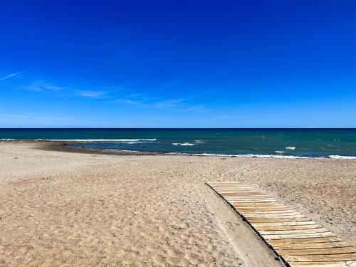 a wooden path on a beach near the ocean at Private garden 100 m from the sea in Benicàssim