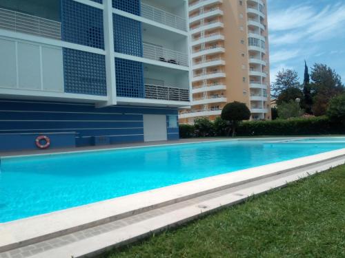 a swimming pool in front of a building at Sunny apartamento in Portimão