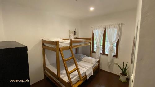 een kamer met een stapelbed en een raam bij CED Villas in El Nido