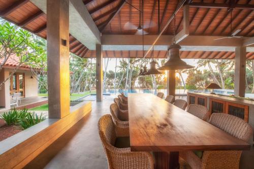 本托塔的住宿－Kirana - A Santani Villa，一间带木桌和椅子的用餐室