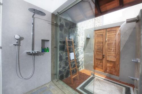 a shower with a glass door in a bathroom at Kirana - A Santani Villa in Bentota