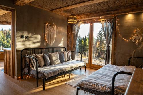 a living room with a couch and a window at Górna Chata Mountains Chalet - Stable Cottage in Ochotnica Górna