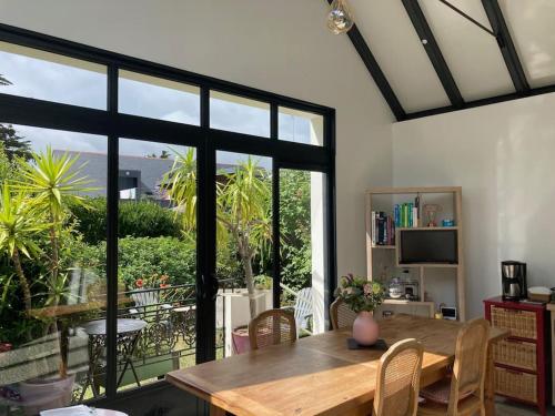 een eetkamer met een tafel en een groot raam bij Maison : L'Ecrin de l'Océan, 80 mètres de la Plage. in Le Pouliguen