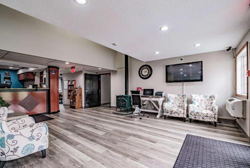 a living room with a table and chairs and a tv at Days Inn by Wyndham Brunswick Bath Area in Brunswick