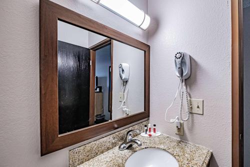 a bathroom with a sink and a mirror and a phone at Days Inn by Wyndham Brunswick Bath Area in Brunswick