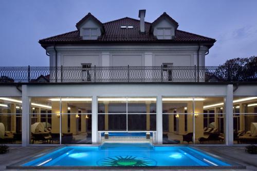 une maison avec une piscine en face de celle-ci dans l'établissement Pałac Żelechów Spa & Wellness, à Żelechów
