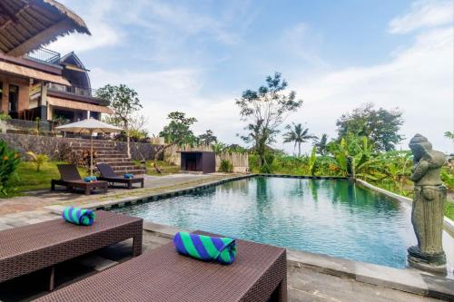 uma piscina num resort com bancos e uma fonte em AlamGangga Villas Tirta Gangga em Tirtagangga
