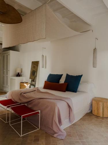 a bedroom with a large bed and a red chair at Amagatay Luxury Boutique Hotel - Adults Only in Alaior