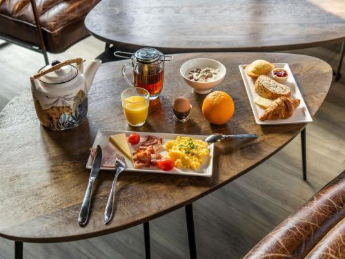 - une table de petit-déjeuner avec une assiette de petit-déjeuner dans l'établissement Ibis Paris Nord Villepinte Parc des Expositions, à Roissy-en-France