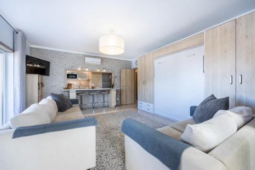 a living room with two couches and a kitchen at Convista Flat T2+1 in Portimão
