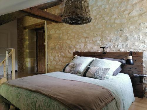 CahuzacにあるGîte "le pitous"の石壁のベッドルーム1室(ベッド1台付)