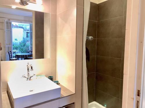 une salle de bain avec un lavabo et une douche dans l'établissement Aparthotel Riviera - Terrasse Mistral Grimaldi Promenade des Anglais, à Nice
