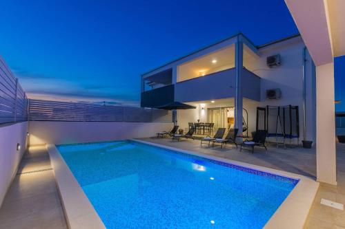 a house with a swimming pool at night at Villa Ema and Ana in Pula