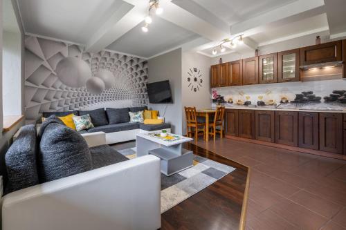 a living room with a couch and a kitchen at RentPlanet - Apartamenty Krzeptówki in Zakopane