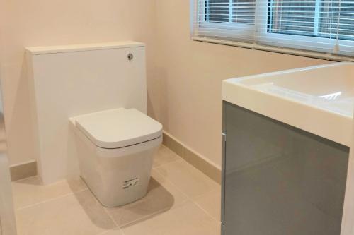 a bathroom with a white toilet and a sink at 1 Bed Cottage-Museum View-Garden-Free Parking in Weybridge