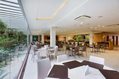 a dining room with tables and chairs in a restaurant at TRYP by Wyndham Manaus Aeroporto in Manaus