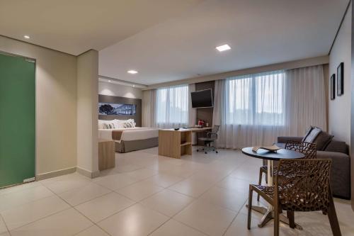 um quarto de hotel com uma cama, uma mesa e cadeiras em TRYP by Wyndham Manaus em Manaus