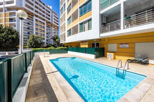a swimming pool in the courtyard of a apartment building at Convista Flat T2+1 in Portimão