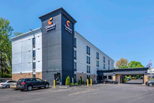 a building with a car parked in a parking lot at Comfort Inn & Suites Liverpool - Syracuse North in Liverpool