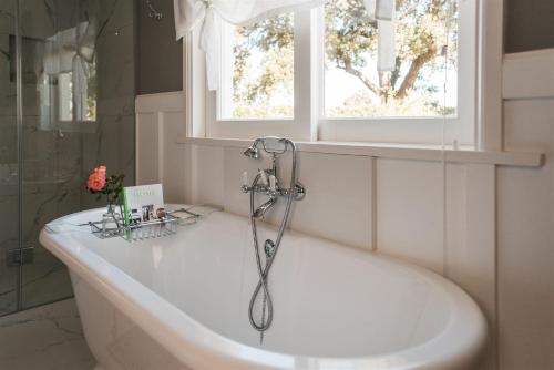 a bath tub in a bathroom with a window at Woodlands Villa in George