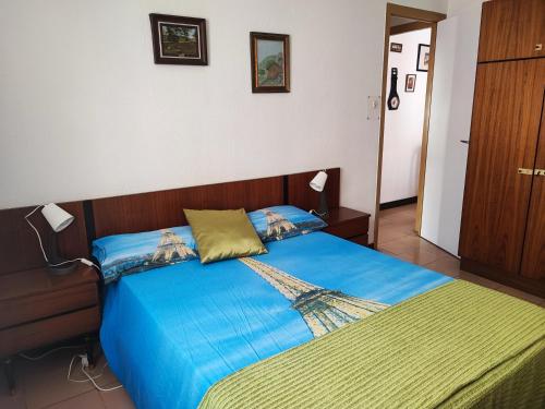 a bedroom with a bed with a blue comforter at Piso temporal Barcelona in Barcelona