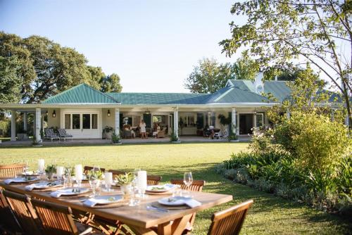 a long wooden table in front of a house at Woodlands Villa in George