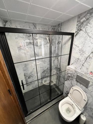 a bathroom with a toilet and a glass wall at EXEN BY WEEKEND in Bodrum City