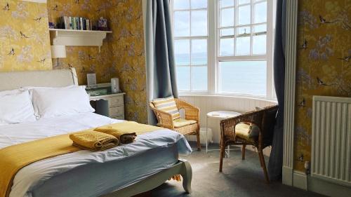 - une chambre avec un lit, une chaise et une fenêtre dans l'établissement Whitecliff Guest House, à Weymouth