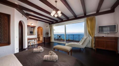 Un dormitorio con una cama con vista al mar. en Luxury villa with stunning view, en Mošćenička Draga