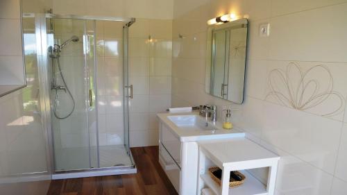 a white bathroom with a shower and a sink at Spacious poolside villa with beautiful garden in Kringa in Pinezići