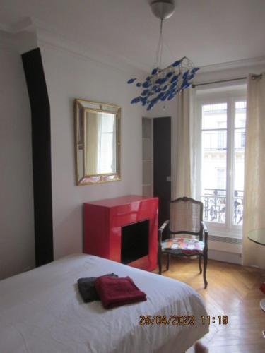 1 dormitorio con cama, chimenea y espejo en Bed and Breakfast Paris Centre, en París