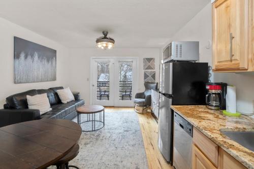 a kitchen and living room with a black refrigerator at River Location 2 blocks to lift 7 &to the Gondola in Telluride