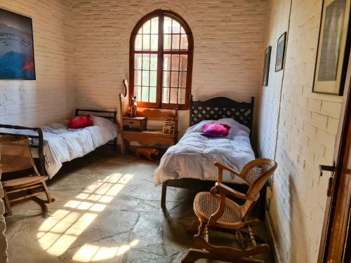1 dormitorio con 2 camas, 2 sillas y ventana en Sitio Santa Filomena, en Vinhedo