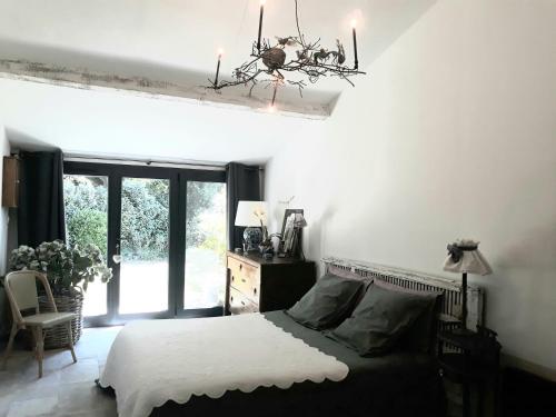a bedroom with a bed and a chandelier at Le Mas des Anges de Flo in Aix-en-Provence