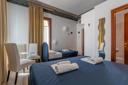een slaapkamer met 2 bedden en een tafel en stoelen bij Hotel ai do Mori in Venetië