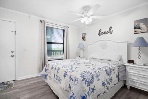 a white bedroom with a bed and a window at Myrtle Beach Resort A402 in Myrtle Beach