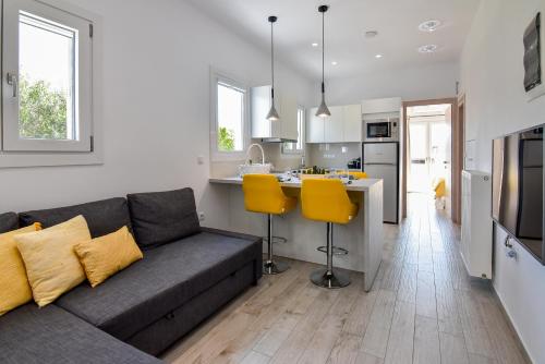a living room with a couch and a kitchen at White Rock Milos Suites in Adamas