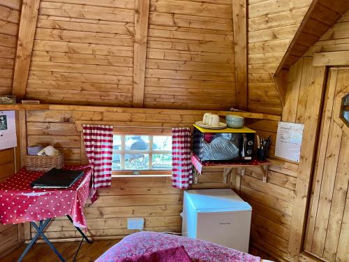 Zimmer mit einem Tisch und einem Fenster in einer Hütte in der Unterkunft The Nest Glamping Pod in Dalmally