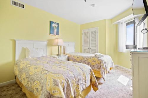 two beds in a room with yellow walls at Myrtle Beach Resort T1402 in Myrtle Beach