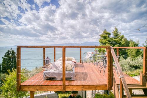 a bed on a deck overlooking the water at Magical view studios Asproneri, Kamena Vourla in Kamena Vourla