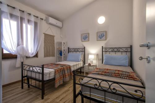 a bedroom with two beds and a window at Villa Aloe in Costa Paradiso