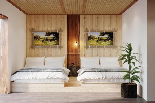 due letti in una stanza con due finestre di CAMELLIA ECO HOME &TRÀ MY RESTAURANT a Ninh Binh