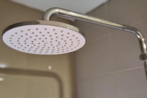 a shower with a shower head in a bathroom at Apt Pejaten Park 1BR Latte w/ Netflix in Jakarta