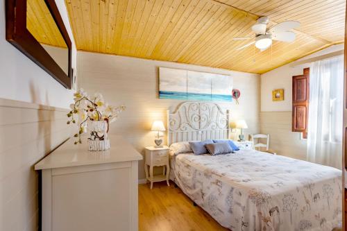 1 dormitorio con cama y techo de madera en Cas Padri by dracmallorca en Santanyí