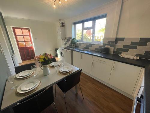 a kitchen with a table with plates and wine glasses at House Nr Bailgate Area and Cathedral Off road Parking and Garden in Lincoln