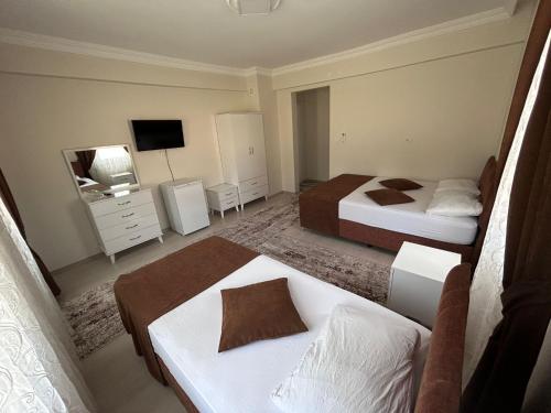 a hotel room with two beds and a television at Paradise House in Pamukkale