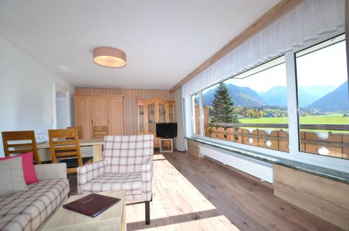 a living room with a couch and a large window at Hotel Cafe Fuggerhof in Oberstdorf