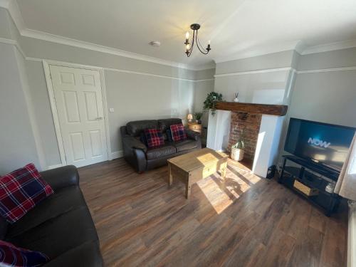 a living room with a couch and a television at House Nr Bailgate Area and Cathedral Off road Parking and Garden in Lincoln