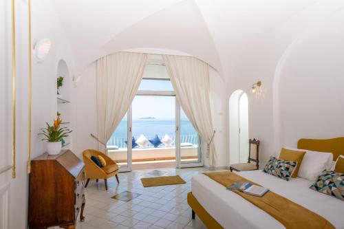 a bedroom with a bed and a view of the ocean at YourHome - Villa Aldo Marino in Positano