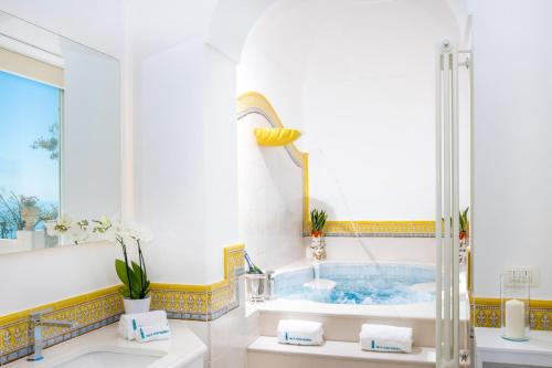 bagno con vasca e lavandino di YourHome - Villa Aldo Marino a Positano